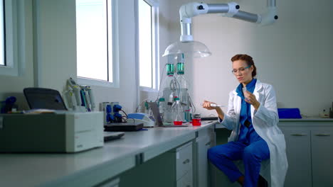 Female-chemist-working-with-liquid-in-chemistry-lab.-Chemical-research